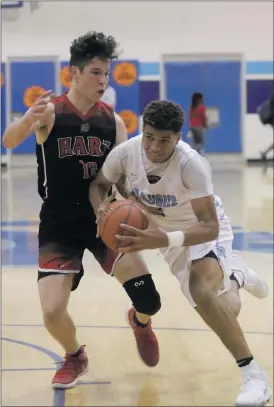  ?? Nikolas Samuels/The Signal ?? Saugus’ Adrian McIntyre (2) drives in toward the basket as he is guarded by Hart’s Whitten Dominguez (10) at Saugus on Friday.