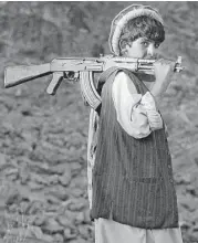  ?? Tom Hanson / Associated Press file ?? An Afghan teenager carries his AK-47 assault rifle in 2003. Russian gun maker Kalashniko­v Kontsern is undergoing a corporate shake-up.