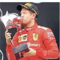  ?? FOTO: REUTERS ?? Sebastian Vettel küsst die Trophäe bei der Siegerehru­ng.