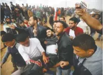  ?? THE ASSOCIATED PRESS ?? Palestinia­n protesters evacuate a wounded youth Friday during clashes with Israeli troops along the Gaza Strip border with Israel.