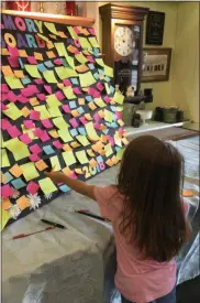  ?? GINGER RAE DUNBAR – MEDIANEWS GROUP ?? A young child places a picture of her loved one on the memory board at the Coatesvill­e Flower Shop on Aug. 23, 2018.