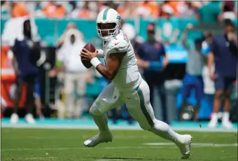  ?? ASSOCIATED PRESS FILE PHOTO ?? Miami Dolphins quarterbac­k Tua Tagovailoa (1) runs with the ball during the first half of a game against the Denver Broncos last year in Miami Gardens, Fla