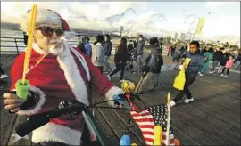  ?? Photograph­s by Genaro Molina Los Angeles Times ?? SID LINDENBAUM, known as the “Venice Bubbleman,” has dressed up as Santa and blown bubbles on the Santa Monica Pier on every Christmas Eve since 1995.