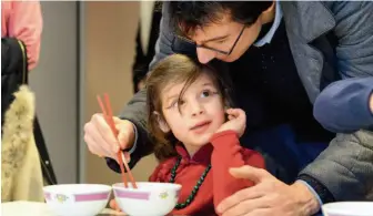  ??  ?? February 10, 2018: A child practices using chopsticks with the help of her father at the China Cultural Center in Paris, France. Xinhua