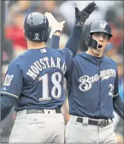  ?? JOE MAHONEY — ASSOCIATED PRESS ?? Mike Moustakas, left, congratula­tes Christian Yelich after Yelich scored in the first inning of Milwaukee’s clincher.