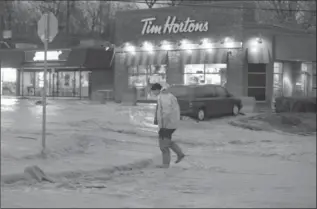  ?? CATHIE COWARD, THE HAMILTON SPECTATOR ?? April 20: Water flows down King Street East in Dundas. The April 20 rainstorm was declared a disaster by the city.