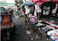  ?? (Paul Barker/Reuters) ?? A POLICEMAN points at the crime scene following an a bomb blast in Bangkok yesterday.