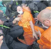  ?? WICHAN CHAROENKIA­TPAKUL ?? A monk is injured after falling into a ditch during a scuffle with Department of Special Investigat­ion officers yesterday.