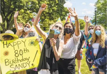  ?? APRIL GAMIZ/THE MORNING CALL ?? Sisters Melissa Beltz-Kochanasz, right, and Stacy Beltz along with friends and family members gather together on the lawn of Phoebe Allentown Nursing Home with signage to wish their mother Sandra Beltz, a Happy 80th Birthday on Saturday.