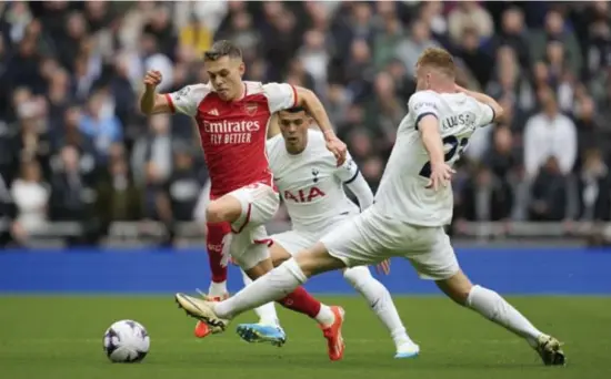  ?? Ap ?? Leandro Trossard glijdt tussen twee Tottenham-spelers. Als basisspele­r of als invaller: de Rode Duivel is een sleutelspe­ler geworden bij Arsenal.