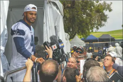  ?? The Associated Press ?? NEW LEADER: Dallas Cowboys quarterbac­k Dak Prescott, left, takes questions from members of the media Friday after the morning walk through practice during the team’s training camp in Oxnard, Calif.