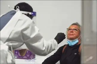  ?? Brian A. Pounds / Hearst Connecticu­t Media ?? After a flight from Florida, Karen Andes, of Auburn, Mass., is swab-tested for COVID-19 at Bradley Airport in Windsor Locks on Tuesday.