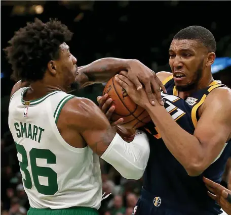  ?? STUART CAHILL / HERALD STAFF ?? DOG FIGHT: Celtics guard Marcus Smart battles for the ball with Utah Jazz center Tony Bradley on Friday night.