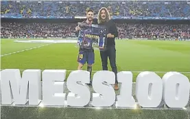  ??  ?? Homenaje. Puyol reconoce a Messi por sus 100 goles en Champions.