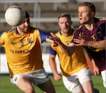  ??  ?? Wexford’s Conor Sinnott handpasses the ball away from defenders Liam Hughes and Daniel Keogh.