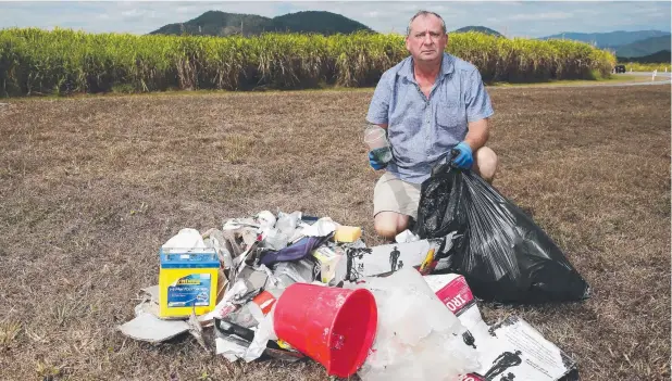  ?? Picture: BRENDAN RADKE ?? SHOCKED: Matt Morton picked up four garbage bags of rubbish and a car battery along a stretch of Holloways Beach Rd.