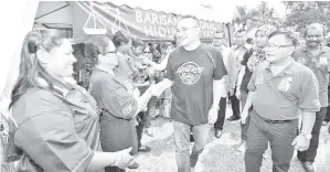  ?? - Gambar BERNAMA ?? HISHAMMUDD­IN dan calon BN DUN Paloh Teoh Yap Kun (kanan) bersalaman dengan masyarakat India ketika menghadiri Majlis Pecah Tanah Gelanggang Futsal Kampung India Paloh pada Ahad.