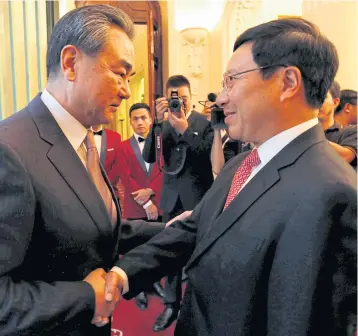  ?? REUTERS ?? China’s Foreign Minister Wang Yi is greeted by Vietnam’s Deputy Prime Minister and Foreign Minister Pham Binh Minh at the Government Office in Hanoi, Vietnam.