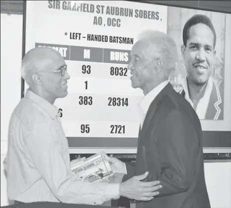  ?? ?? Nasser Khan (left) presenting Sir Garfield Sobers with a copy of his book at the Queen’s Park Oval, 24th November, 2018 (Photo by Ronald Daniel)