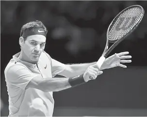  ?? — Gambar AFP ?? KERJA KERAS: Federer ketika beraksi menentang Marin Cilic dari Croatia pada aksi ATP Finals Kejohanan Dunia di O2 Arena di London.