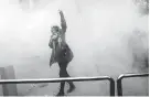  ?? AP ?? A student defies a smoke grenade thrown by police at Tehran University.