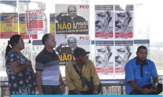  ??  ?? BRASILIA: People wait in Brasilia at a bus stop covered in posters in support of Brazilian former President Luiz Inacio Lula de Silva calling for people to ‘Occupy Porto Alegre on January 24.’ —AFP