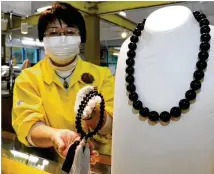  ?? JAPAN NEWS-YOMIURI ?? A necklace and prayer beads made of “Kuji jet” are displayed at a store in Kuji, Japan. The gemstone is in high demand in Europe and the United States.