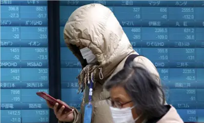  ??  ?? Masked people in Tokyo. Photograph: Eugene Hoshiko/AP