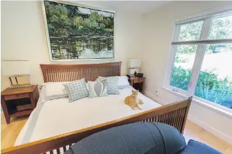  ??  ?? The master bedroom, formerly the living room, has a Scandinavi­an-style bed that echoes much of the home’s sleek, unfussy, custom furniture. Above the bed is a Ted Godwin waterscape.