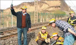  ?? PROVIDED TO CHINA DAILY ?? Yang Jingxing (left) and his colleagues work on repairing a section of railway in Shaanxi province last year.