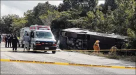  ?? NOVEDADES DE QUINTANA ROO VIA AP ?? Rescuers respond to an overturned bus in Mexico’s southern Quintana Roo state on Tuesday. Authoritie­s provided no explanatio­n as to why the vehicle carrying cruise passengers to the Mayan ruins flipped over.