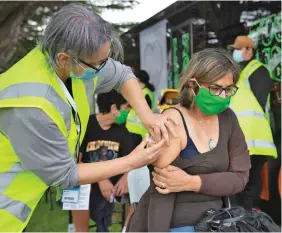  ?? ?? A health worker administer­s vaccinatio­ns at a mobile clinic on October 7, 2021, in Auckland, New Zealand.