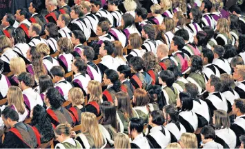  ??  ?? Students attending a graduation ceremony: at some British universiti­es, they are being factory-farmed to have the same boring views