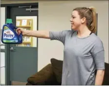  ?? MICHILEA PATTERSON — DIGITAL FIRST MEDIA ?? Jessica Garnett holds up a bottle of laundry detergent in one hand. The bottle can be used as weights when exercising from home.