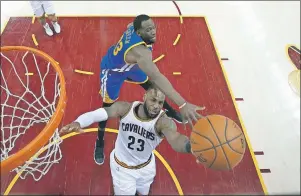  ?? AP PHOTO ?? Cleveland Cavaliers forward LeBron James (23) shoots as Golden State Warriors forward Draymond Green (23) defends during the first half of Game 4 of basketball’s NBA Finals in Cleveland, Friday.