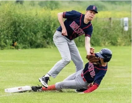  ??  ?? A close diving play at third base in the tense Brunels versus Buccaneers baseball derby