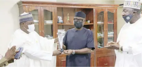  ??  ?? L-R: Nasir Sani-gwarzo, permanent secretary, Ministry of Industry, Trade and Investment, presenting the award of excellence in public service conferred on Adeniyi Adebayo, minister of industry, trade and investment, by Businessda­y newspaper to the minister in his office. With them is Abubakar Dangaladim­a, director, weight and measure in the ministry.