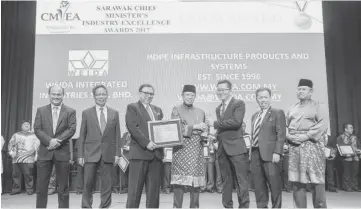  ??  ?? Tan (third right) receives the award from Abang Johari (centre), as (from right) Morshidi, Dr Sim, Abang Abdul Karim and others look on.