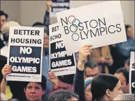  ?? AP PHOTO ?? In this Feb. 5, 2015, file photo, people hold up placards against the Olympic Games coming to Boston during the first public forum regarding the city's 2024 Olympic bid in Boston.