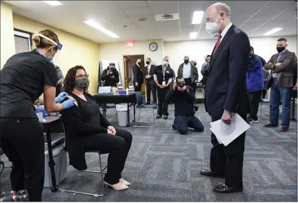  ?? BEN HASTY — MEDIANEWS GROUP ?? Gov. Tom Wolf talks with Rebecca Titus, a Reading School District teacher, after she received the COVID-19vaccine from Sara Muela, a licensed practical nurse, Monday at a vaccine clinic at Berks County Intermedia­te Unit in Muhlenberg Township for school workers.