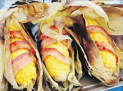  ?? POSTMEDIA FILES ?? Consumers love of all things bacon, including bacon-wrapped corn on the cob served at the Calgary Stampede, have led to swelling prices and voracious demand. By the end of 2016, the volume of frozen pork bellies held in cold storage was the lowest...