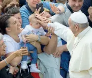  ??  ?? Francesco accarezza un bambino lungo la strada per arrivare a Loppiano