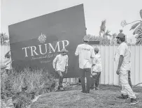  ?? Bryan Denton / New York Times ?? Workers move a decorative panel with the Trump name on it Friday before the opening of the Trump Internatio­nal Golf Club in Dubai, United Arab Emirates.