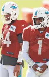  ?? GETTY ?? Ryan Fitzpatric­k, left, and Tua Tagovailoa look on during training camp. Fitzpatric­k will open the season as Miami’s starting quarterbac­k.