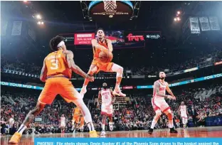  ?? —AFP ?? PHOENIX: File photo shows, Devin Booker #1 of the Phoenix Suns drives to the basket against the Houston Rockets on February 07, 2020 at Talking Stick Resort Arena in Phoenix, Arizona.