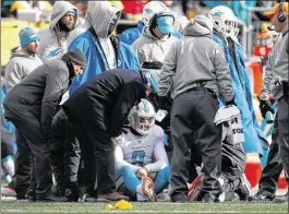  ?? ROB CARR / GETTY IMAGES ?? Dolphins quarterbac­k Matt Moore receives attention on the sideline after taking a hit during the second quarter of Miami’s playoff loss at Pittsburgh.