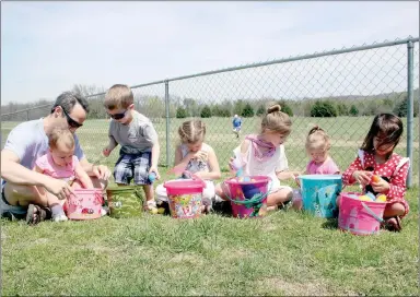  ??  ?? Above: These children check out their candy stash from the Eggstravag­anza held Saturday in Farmington: Wade Wright helps his daughter Stella Wright, 15 months, open her eggs. Others sitting here are Mason Wright, 3, Londyn Thorn, 6, Lilah Thorn, 7,...