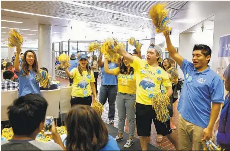  ?? Jay L. Clendenin Los Angeles Times ?? UCLA STUDENTS and staff cheer on a newly registered student during Bruins Day in April 2016. The university will turn 100 next year.