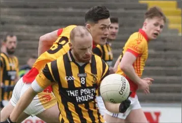  ??  ?? Shelmalier­s captain Aidan Cash keeps the ball away from Sarsfields star Lee Chin.