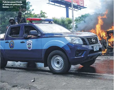  ?? /EFE ?? Policías pasan frente al vehículo policial en llamas.